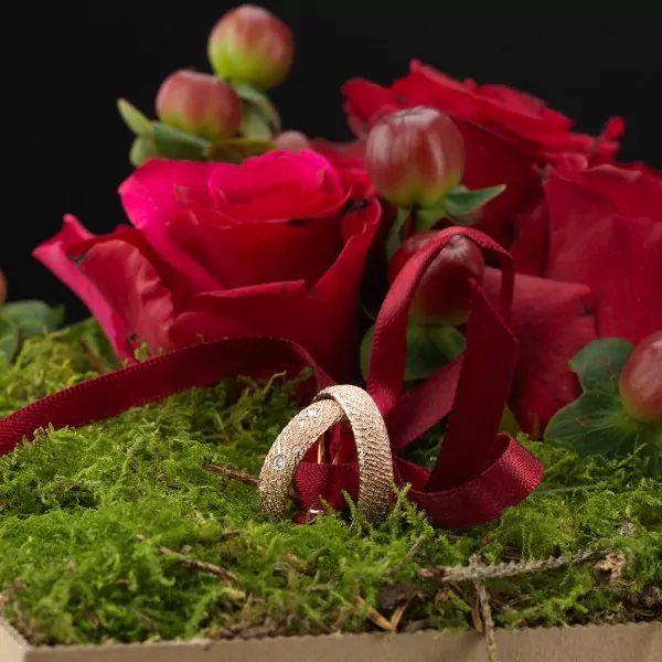 Eheringe elegant überreichen: Die Loving Nature blühauf-Blumenbox zaubert ein Lächeln auf ihre Lippen.